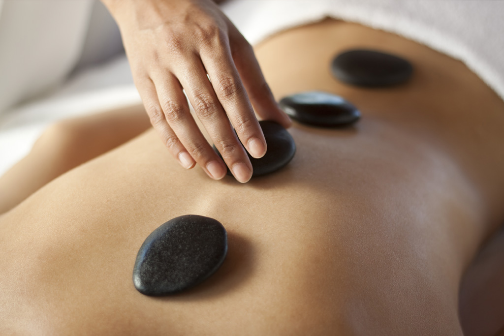 Top view of a person having a hot stone massage at Tula Massage